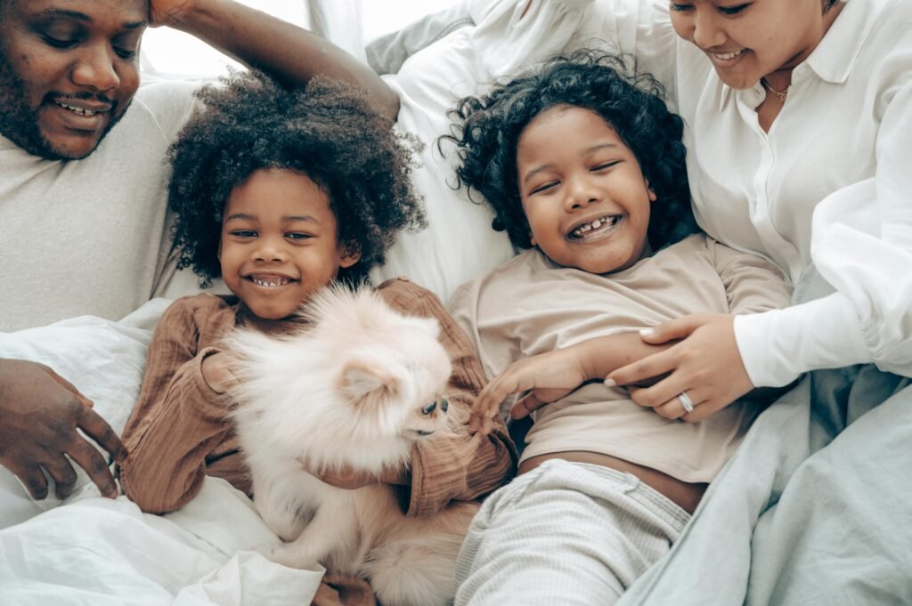 Happy family bonding time with kids and a Pomeranian dog in cozy home setting.