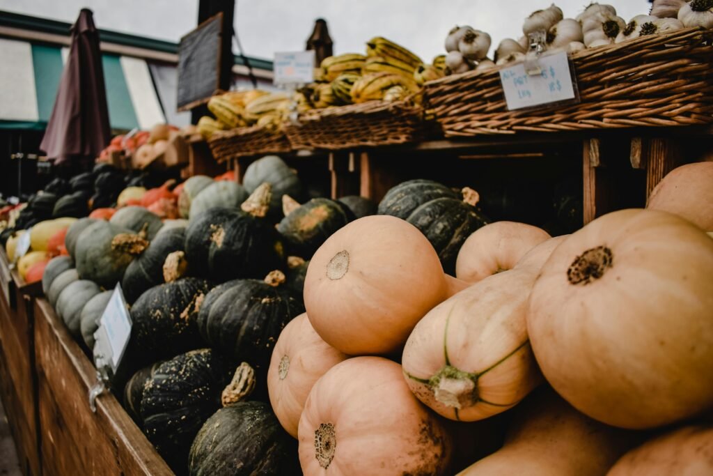 A vibrant display of squash, pumpkins, and garlic at a Montreal market food stall.